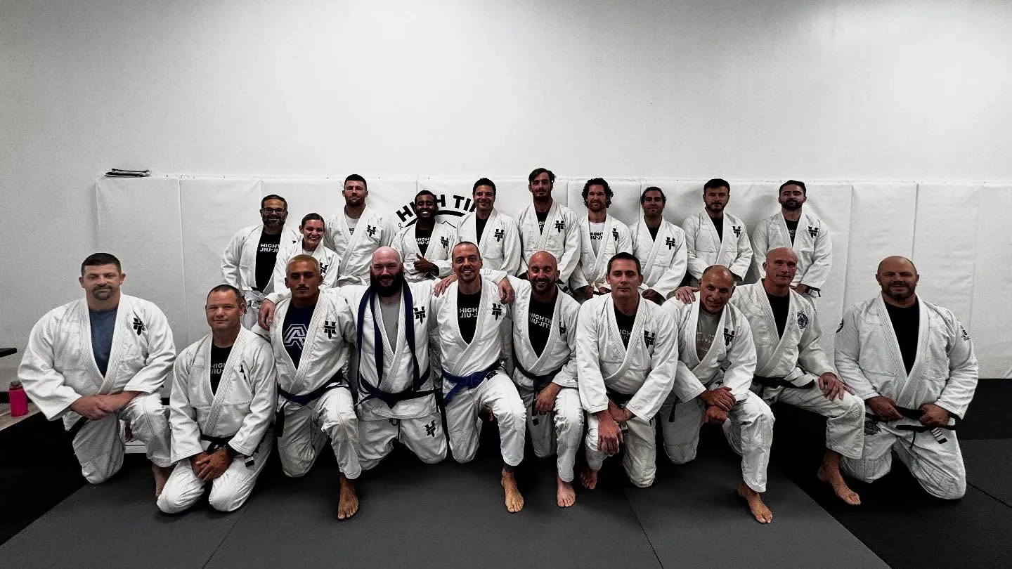 The High Tide Jiu Jitsu adult team kneeling together in gi on the mats in Sea Girt